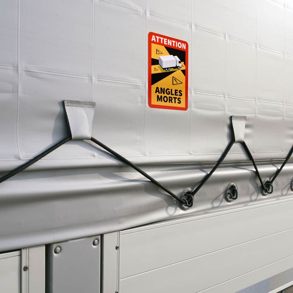 „Angles Morts“-Warnschild auf Lkw-Plane, sichtbar auf gespannter Seitenfläche