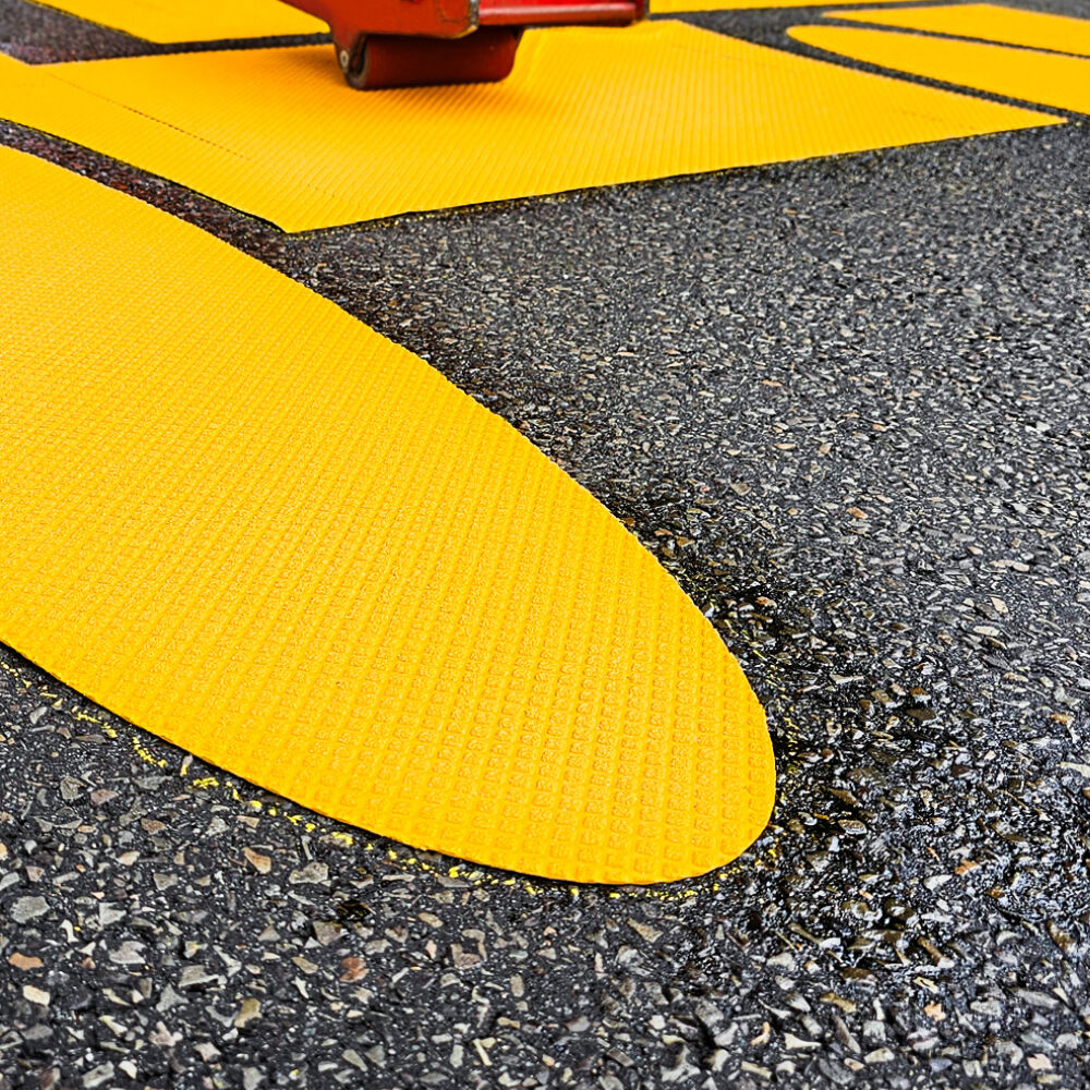 3M Andruckrollgerät RTC 3 im Einsatz auf gelber Fahrbahnmarkierungsfolie, Nahaufnahme