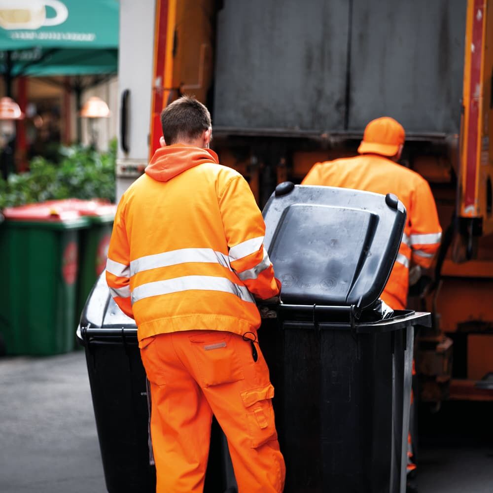 Müllabfuhr in orange Warnkleidung mit Reflexgewebe 9925+ beim Entleeren von Tonnen