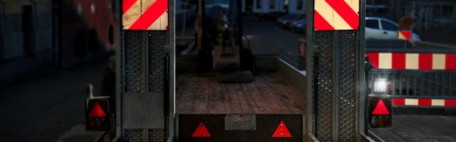 Lichttechnische Einrichtungen gemäß StVZO § 49a Baustellenabsicherung mit rot-weißen Warnschildern und reflektierenden Dreiecken bei Dämmerung