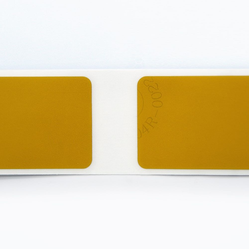 Nahaufnahme zweier gelber Markierungssegmente mit abgerundeten Ecken auf weißem Untergrund