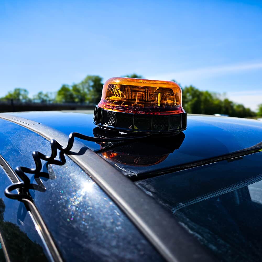 LED-Magnet‐Rundumleuchte auf Fahrzeugdach montiert, Versorgung über Spiralkabel