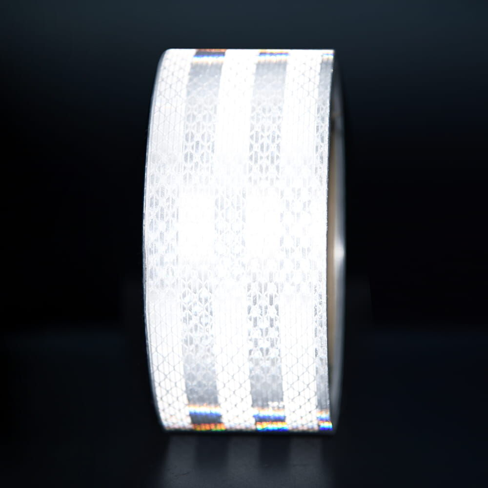 50 mm Rolle 3M Reflexband 3930 weiß, reflektierend vor dunklem Hintergrund