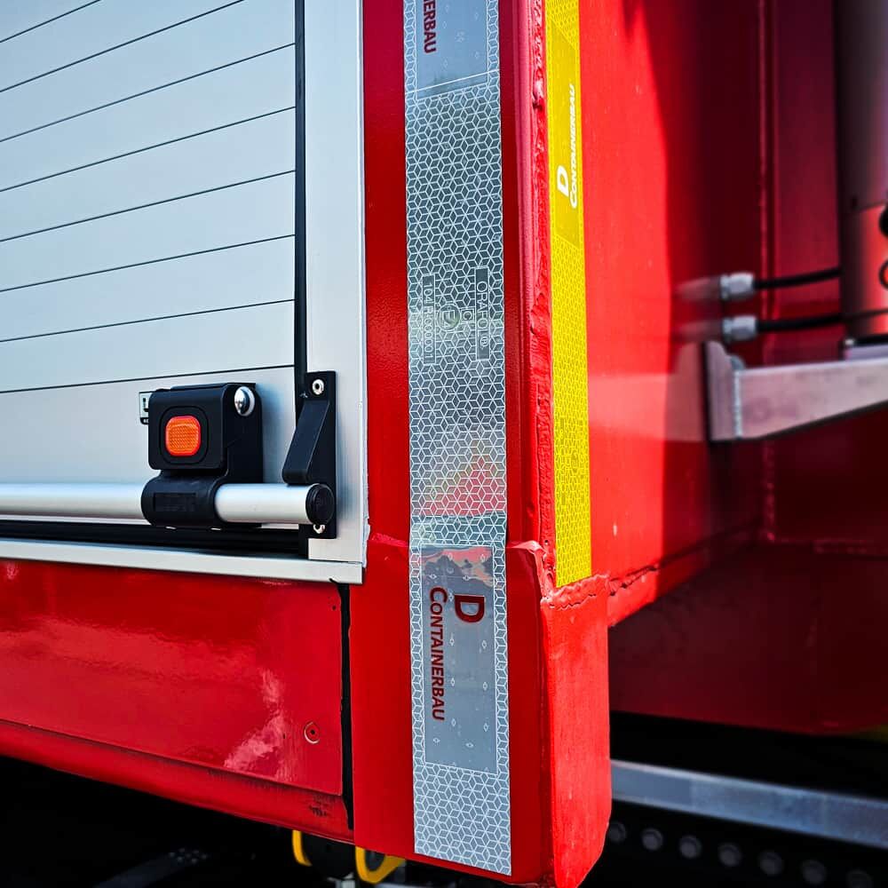 Weißer & gelber Logo-Streifen VC 104+ RG als Konturmarkierung am roten Container