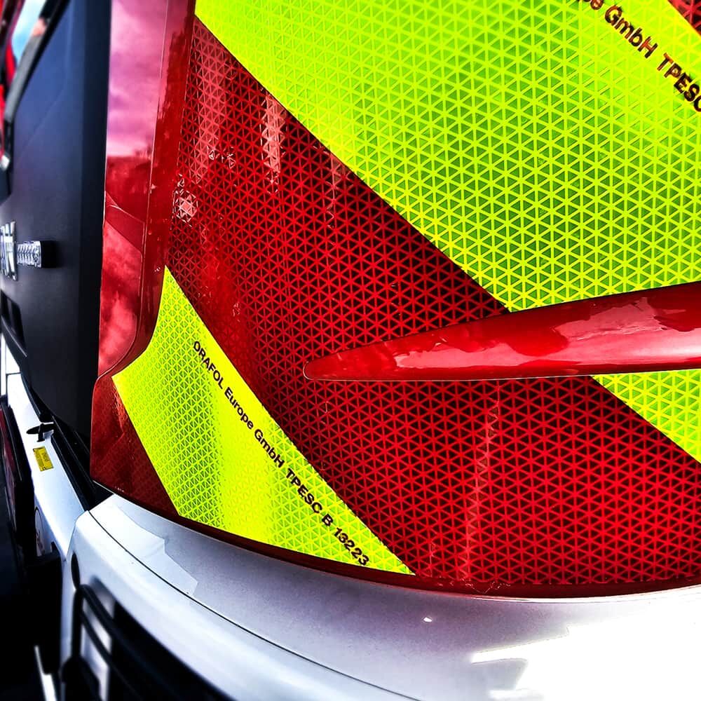 Nahaufnahme ORALITE VC 612 Warnmarkierung fluorlime-rot am Frontbereich eines Feuerwehrfahrzeugs.