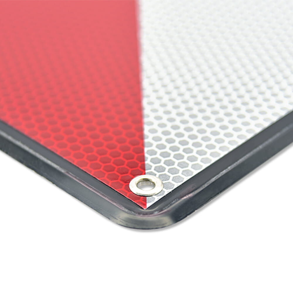 Detail Ecke: rot-weiße Reflexfolie, Metallöse und schwarzer Rahmen