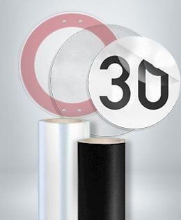 RGEditDas Bild zeigt zwei Verkehrsschilder: ein rundes Tempolimit-Schild mit "30" und ein rotes Verbotsschild. Unten sind Rollen mit reflektierender Folie für die Herstellung von Verkehrsschildern zu sehen.