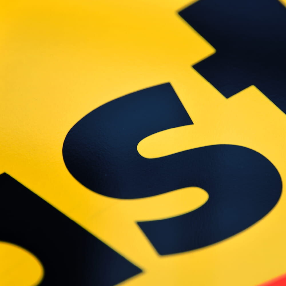 Nahaufnahme der schwarzen Schrift auf gelber reflektierender Fläche