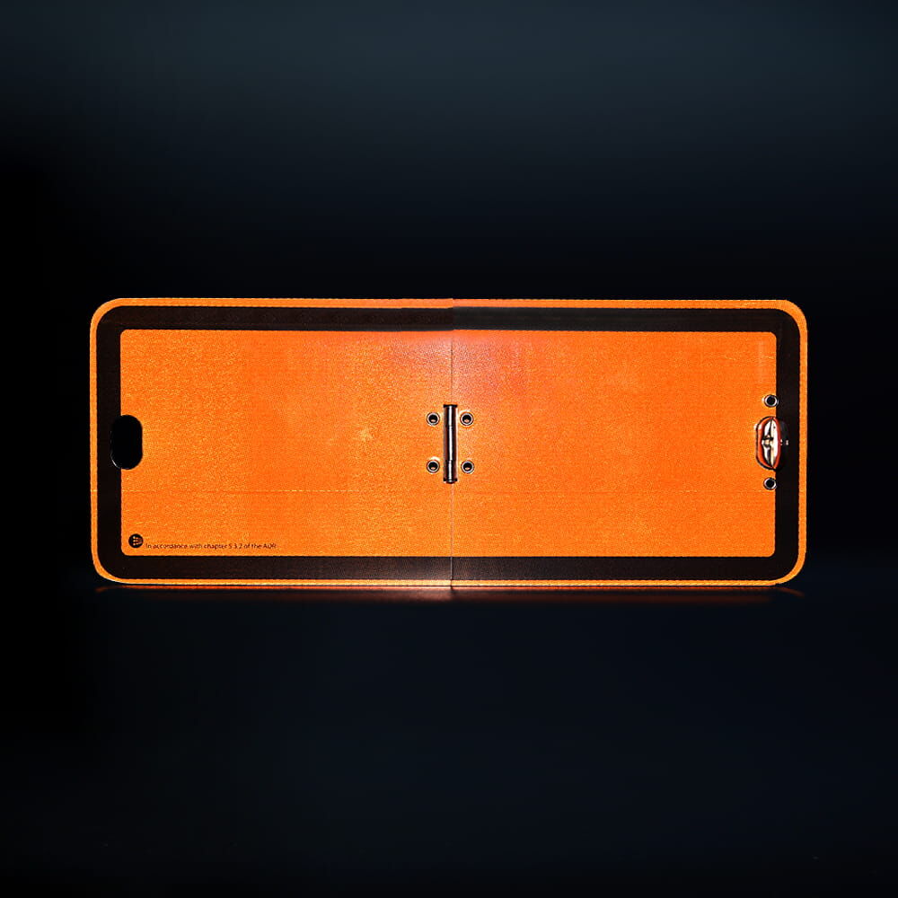 Reflektierende ADR Klapptafel klein bei Dunkelheit, leuchtet orange auf schwarzem Grund