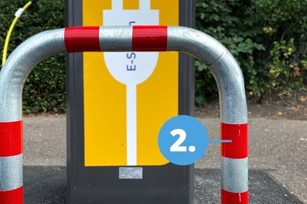 Ein mit der ORALITE VC 612 markierter Poller vor einer E-Ladesäule auf einem E-Auto Parkplatz