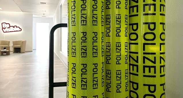Reflexfolienrollen mit schwarzem Aufdruck „POLIZEI“ im modernen Büroflur.