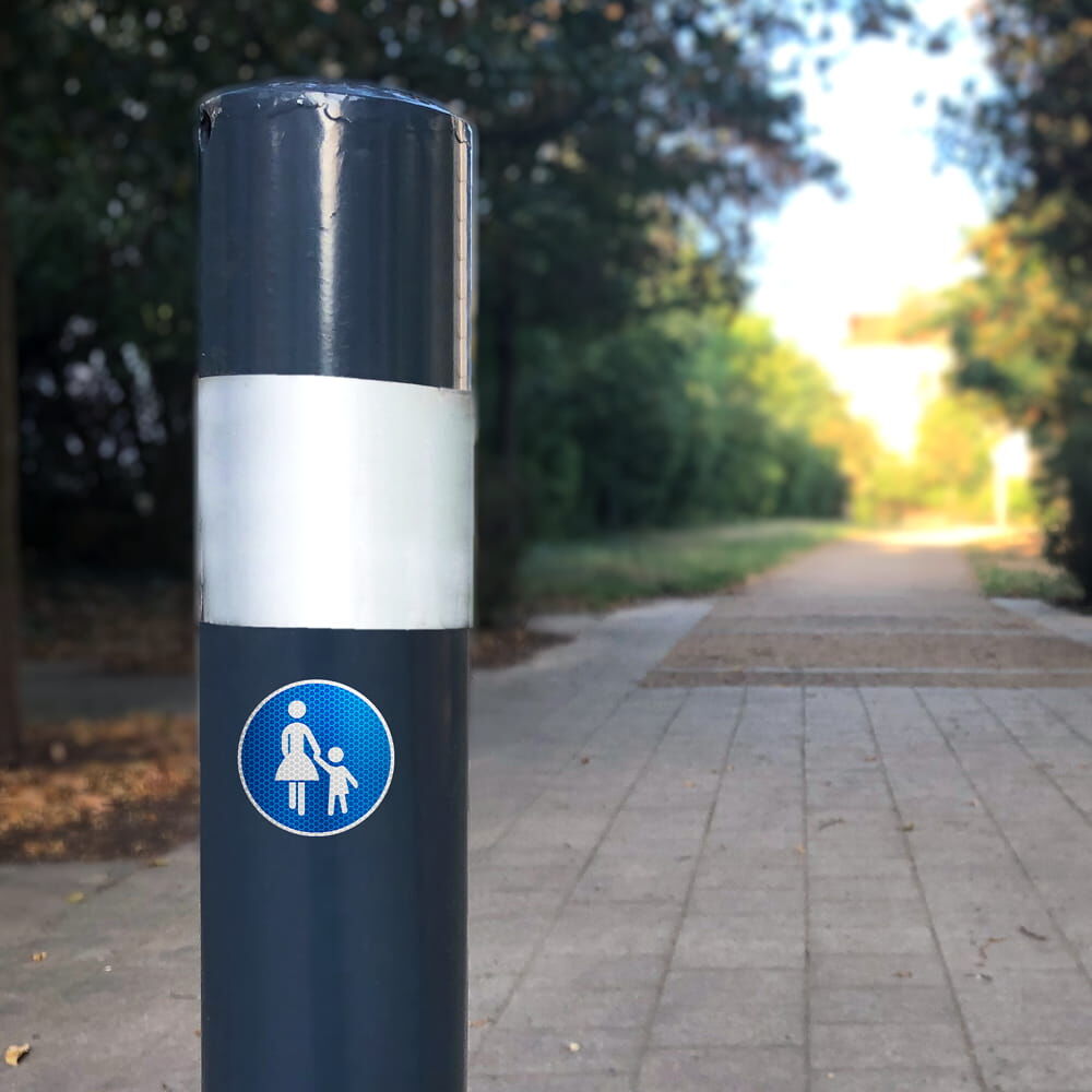Gehweg-Aufkleber an einem Poller im Außenbereich, Symbol Frau mit Kind