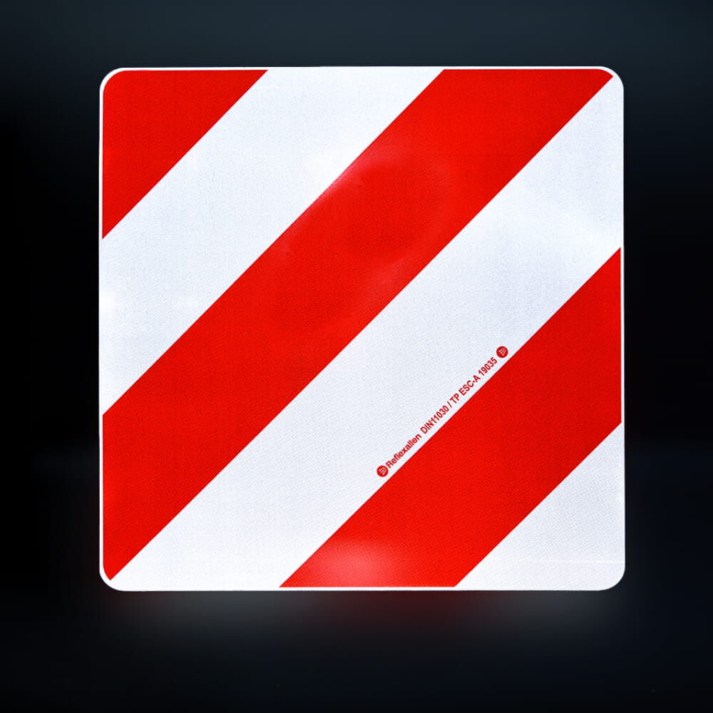 Reflektierende Warntafel Überlänge/Überbreite bei Nacht auf dunklem Hintergrund