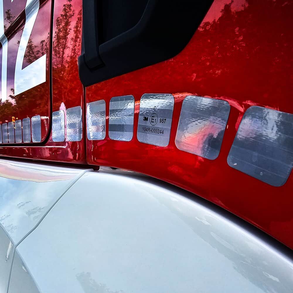Rotes Fahrerhaus mit silbernen 3M 957S Quadraten entlang der Tür.