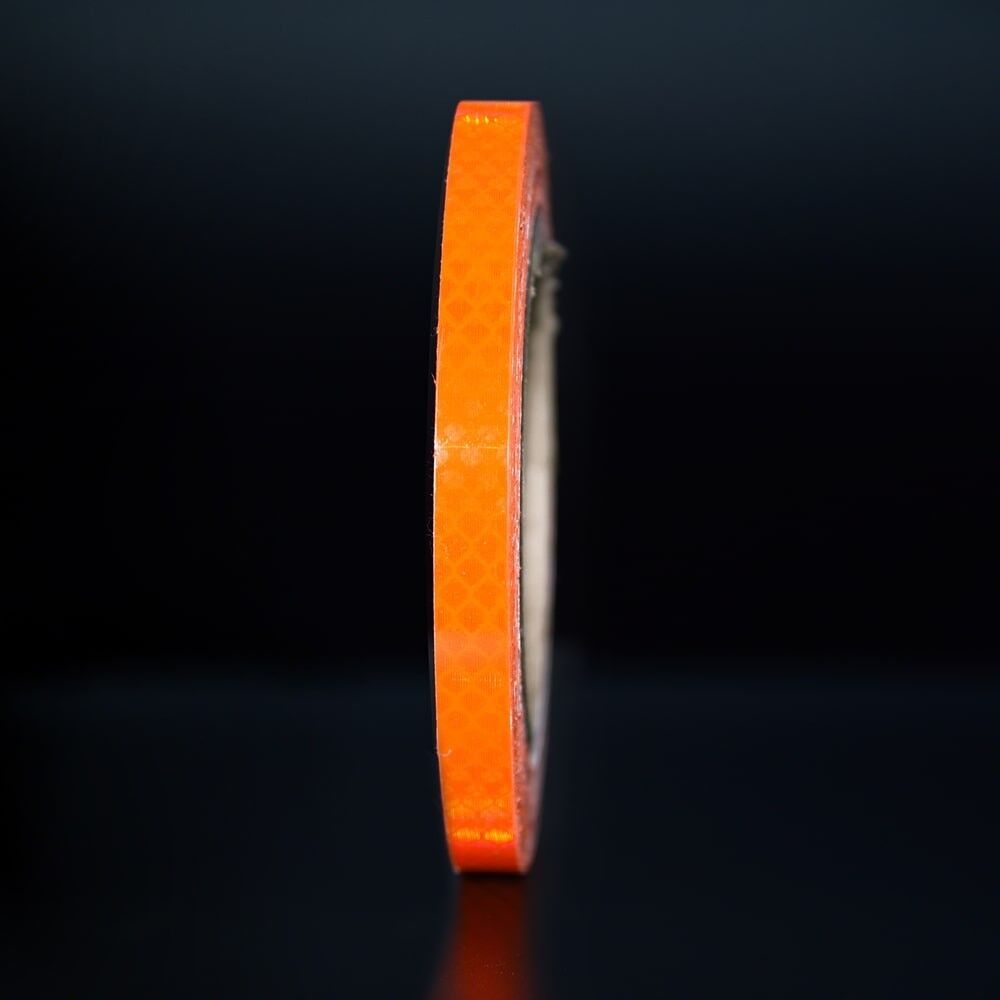 10 mm Rolle 3M Reflexband 4080 Fluor-orange, reflektierend vor dunklem Hintergrund