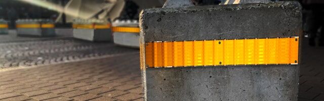Leitplanken-Reflektor Reflex-Profil Eine Betonbarriere mit gelbem LDs-Panel, das die Sicherheitszone eines öffentlichen Platzes markiert und den Zugang einschränkt.