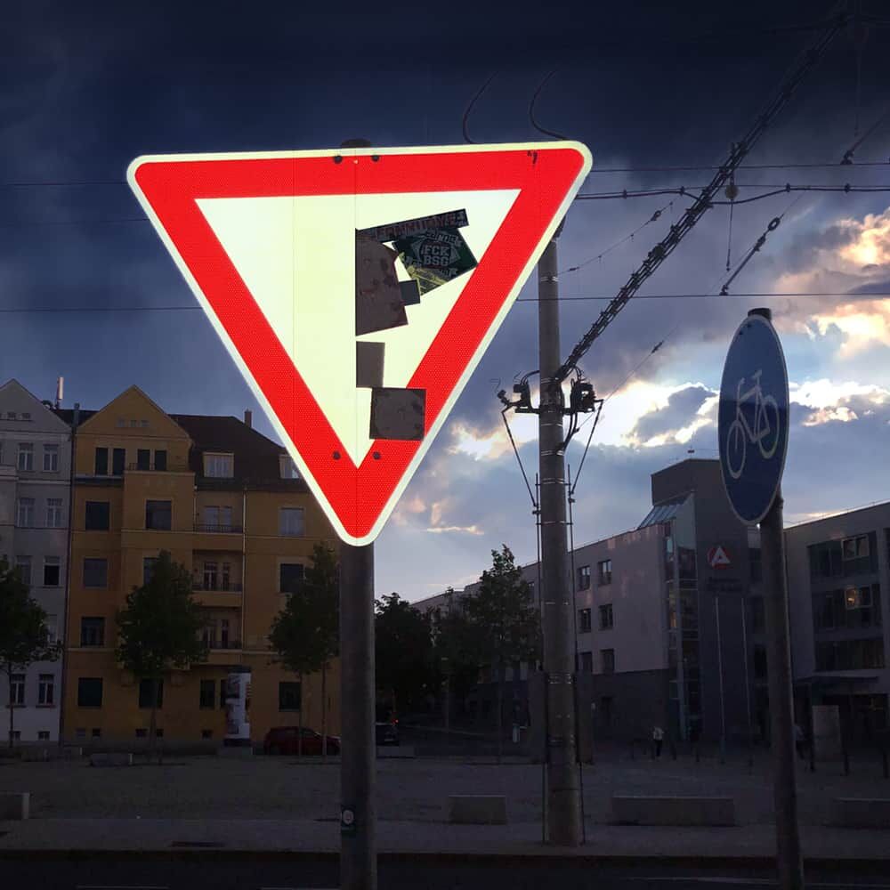 Dreieck-Vorfahrtsschild bei Dämmerung, geschützt durch Astifol Anti-Sticker-Film.