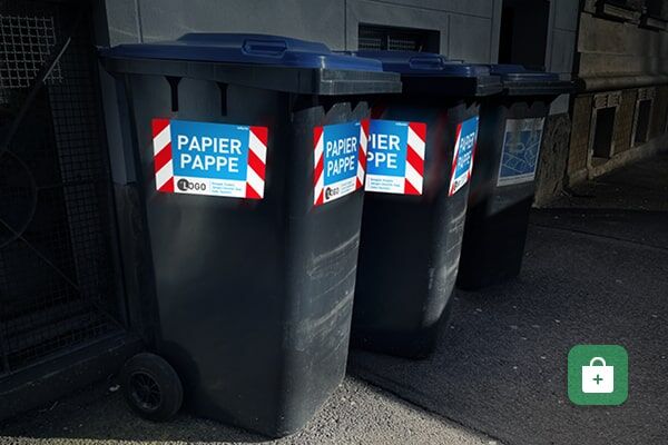 Graue Papiertonnen mit blauen Deckeln und rot-weißen Warnschildern „PAPIER PAPPE“ in einer Reihe.