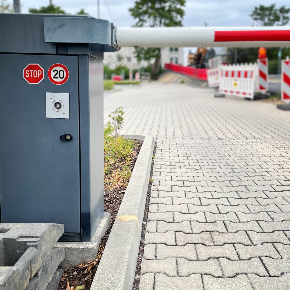 Stop- und Tempo-20-Aufkleber auf Schrankenanlage an Zufahrt
