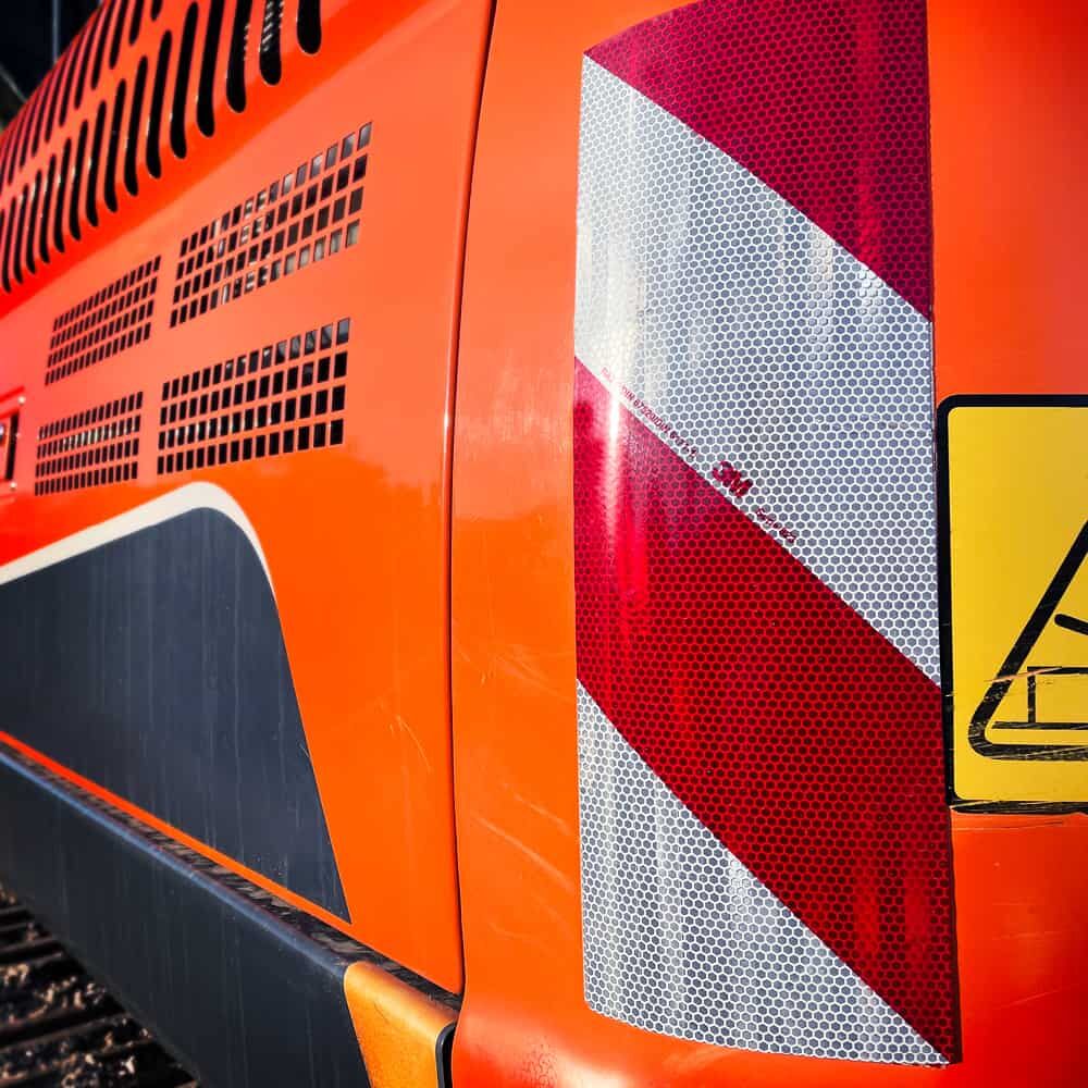 3M 823i Warnmarkierung vertikal an orangefarbener Baumaschine angebracht