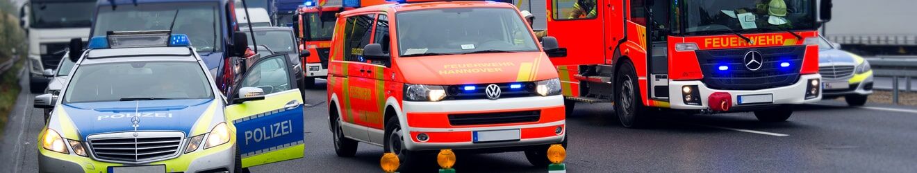 Markierungen speziell für Einsatzfahrzeuge Einsatzfahrzeuge von Polizei, Feuerwehr und Rettungsdienst auf einer Autobahn mit dramatischem Himmel.