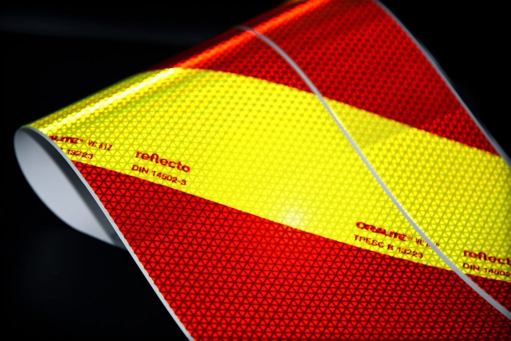 Detailbild der Warnmarkierung, fluorlime-rote Streifen reflektieren, mit Orafol und reflecto Logo