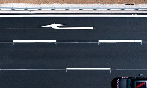 Titelbild Themenseite Fahrbahnmarkierungen Das Titelbild der Themenseite Fahrbahnmarkierung zeigt eine mehrspurige Autobahn mit durchgezogener und Teillinienmarkierung sowie Linksabbiegepfeil