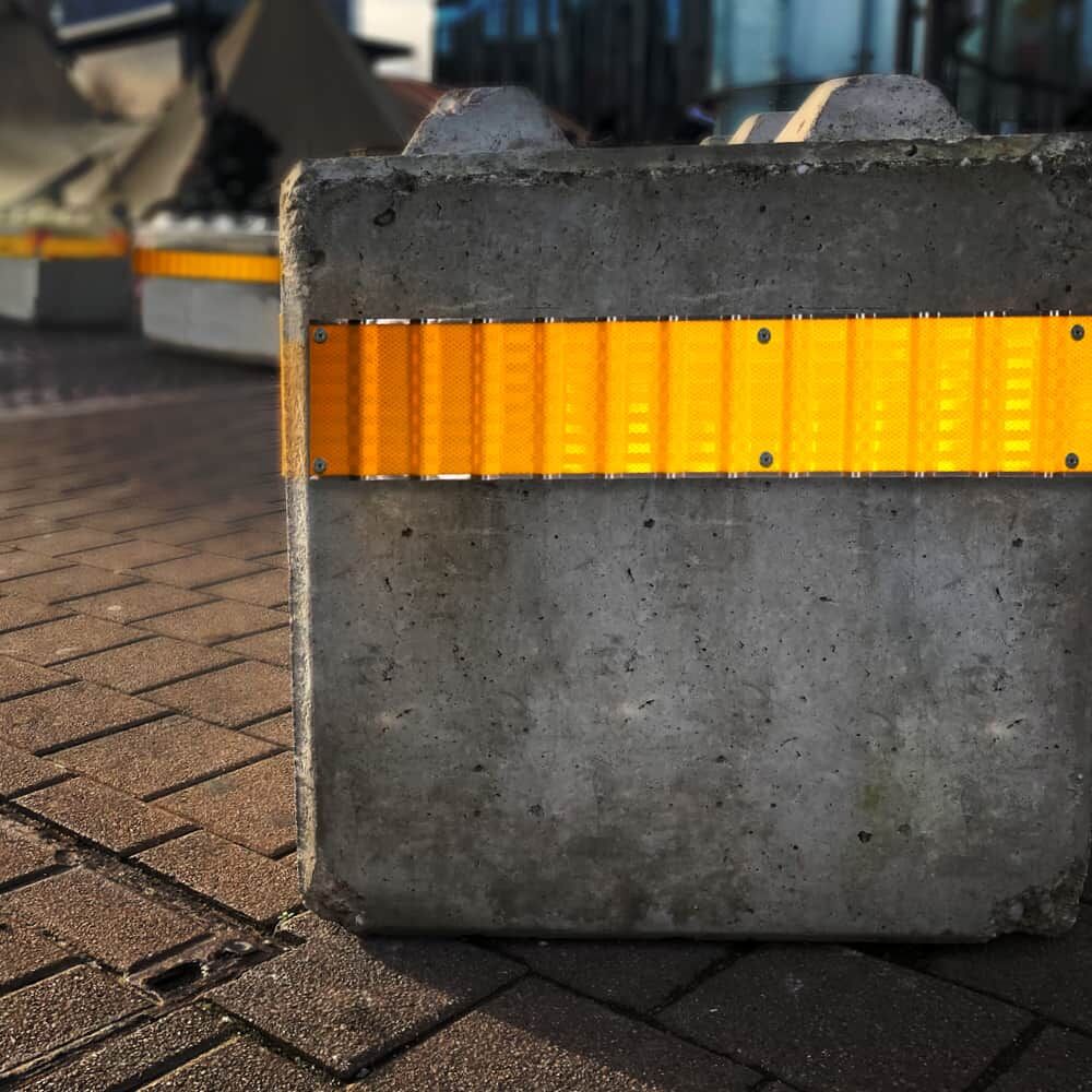 Gelbes 3M Reflex-Profil an Betonleitblock als Sicht- und Warnmarkierung montiert
