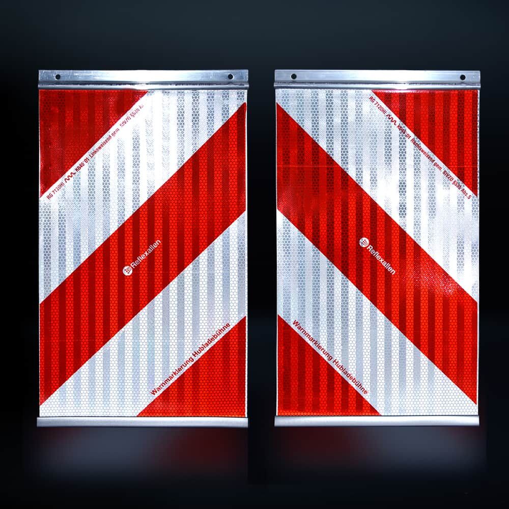 Reflektierende Warnmarkierungen rot-weiß bei Nacht, stark leuchtend im Licht