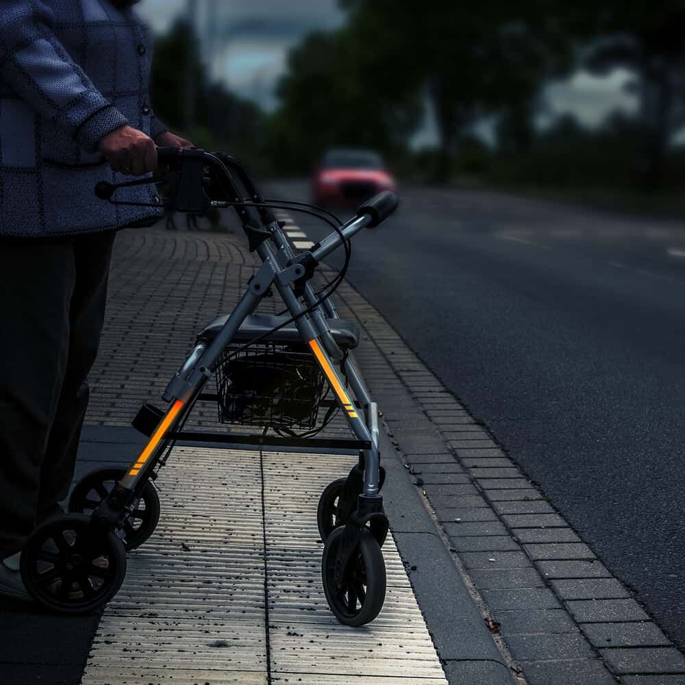 Rollator mit orangefarbenem Reflexband 5600E erhöht Sichtbarkeit am Straßenrand.