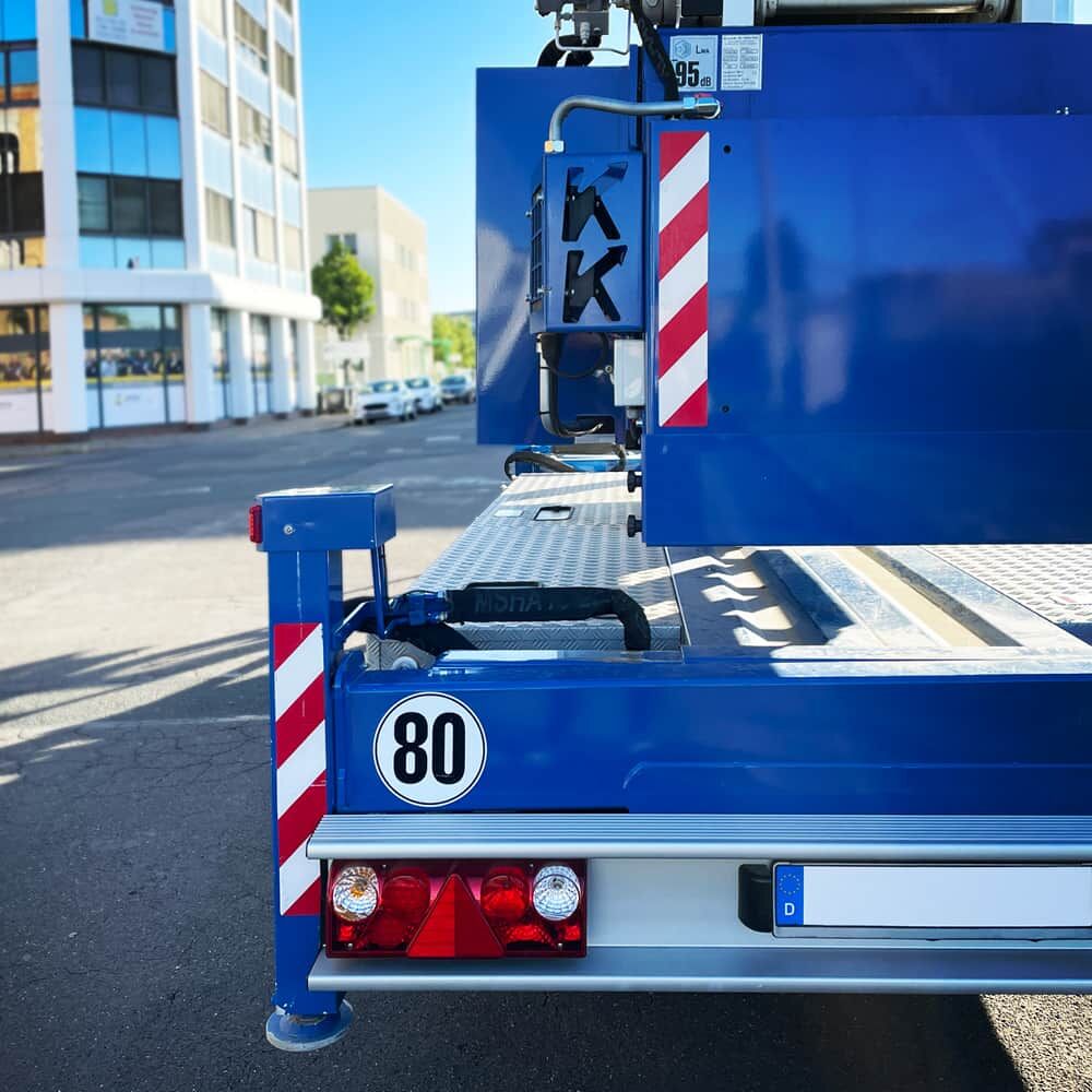 Lkw-Heck mit reflektierendem 80-km/h-Geschwindigkeitsschild und Warnstreifen