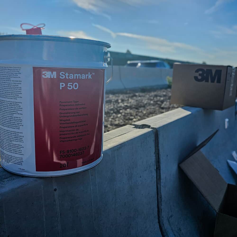20-L-Eimer 3M P50 auf Baustellenbarriere, Morgenlicht, Karton im Hintergrund