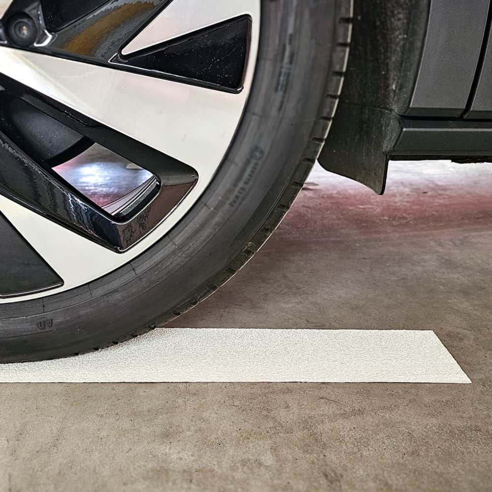 Reifen steht exakt auf robuster 3M Stamark Bodenmarkierung, Nahaufnahme