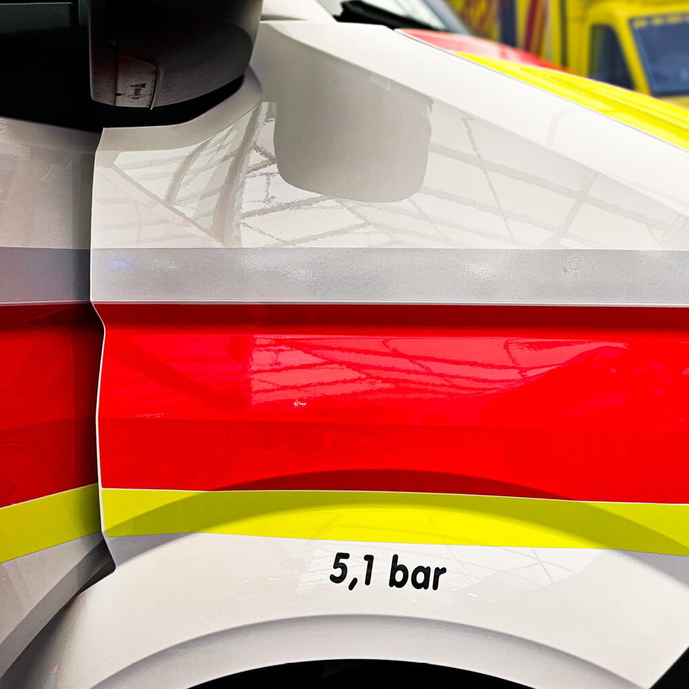 Rettungswagen-Kotflügel betont durch mehrfarbiges Reflexband 5600E seine Kontur.