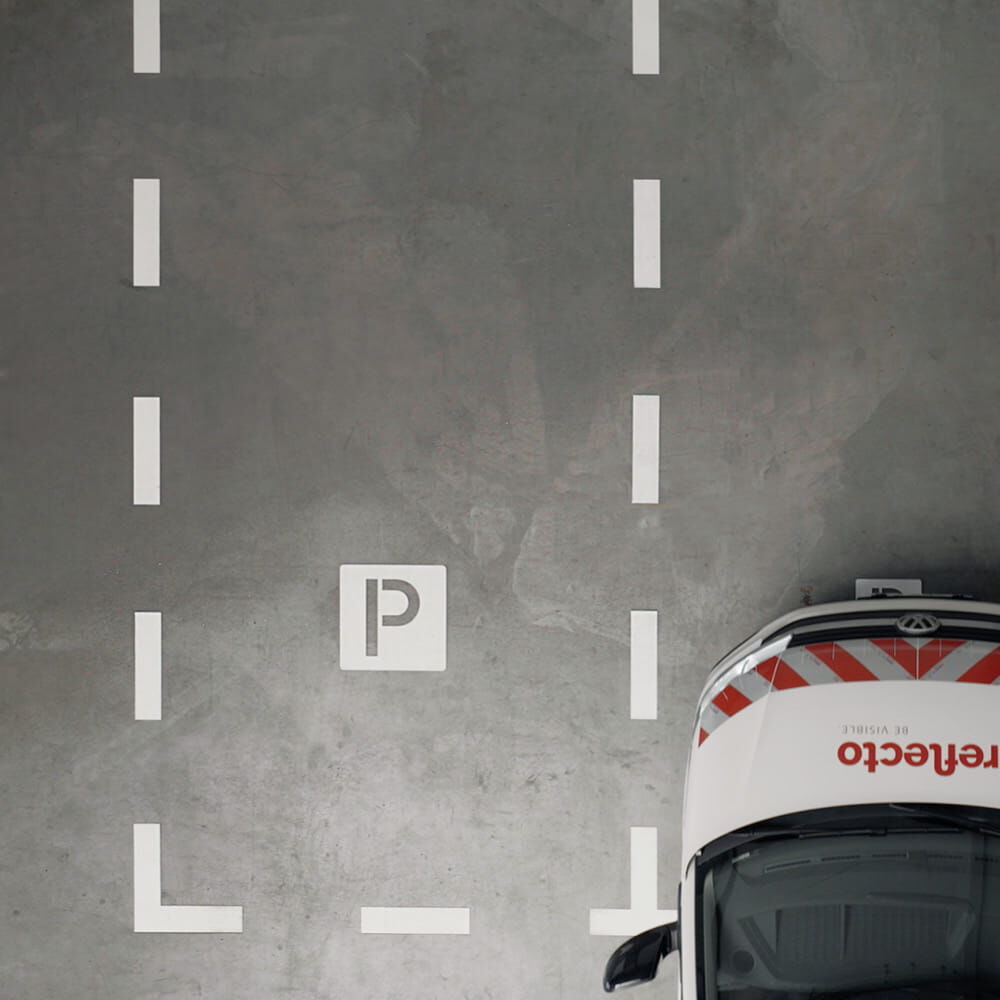 Parkplatz mit weißem 3M Stamark „P“-Symbol und Linienmarkierung auf Betonfläche