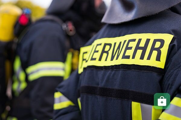 Eine dunkelblaue Feuerwehr-Einsatzjacke mit gelbem reflektierendem 