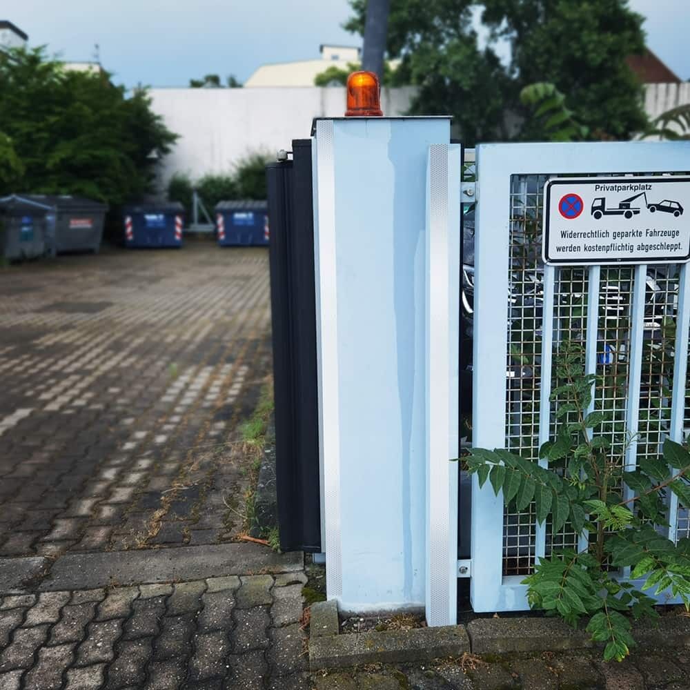 Vertikale weiße 5810-Reflexbänder markieren Torpfosten an Privatparkplatzeinfahrt