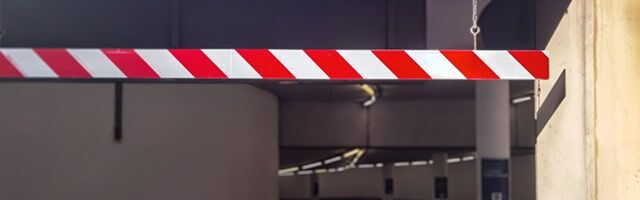Reflexfolie zur Kennzeichnung von Garageneinfahrten Eine rot-weiß gestreifte Höhenbegrenzung in einer Parkgarage oder Tiefgarage.