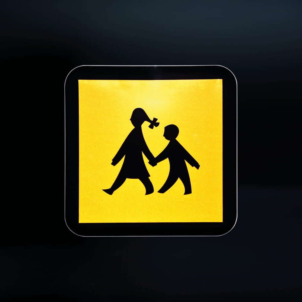 Schulbusschild leuchtet reflektierend gelb bei Lichteinfall in der Dunkelheit