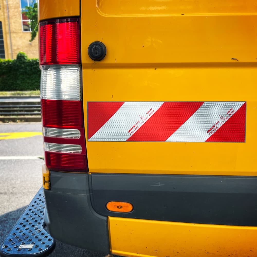 Warnmarkierung 5921M magnetisch auf gelbem Transporter-Heck, rot-weiße Diagonalstreifen