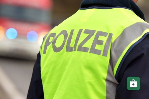 Eine neongelbe Warnweste mit reflektierendem „POLIZEI“-Schriftzug und grauen Reflexelementen.