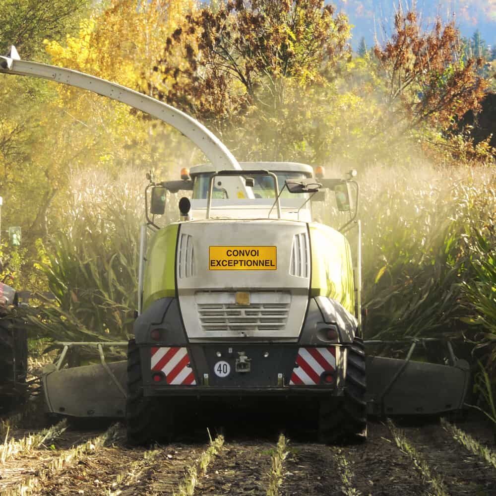Schild „Convoi Exceptionnel“ montiert an einem Erntefahrzeug auf dem Feld