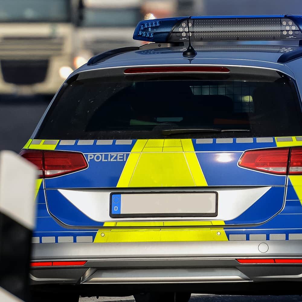 Heck eines Polizeiwagens mit gelb-blauen V-8000-Reflexmarkierungen für maximale Sichtbarkeit.