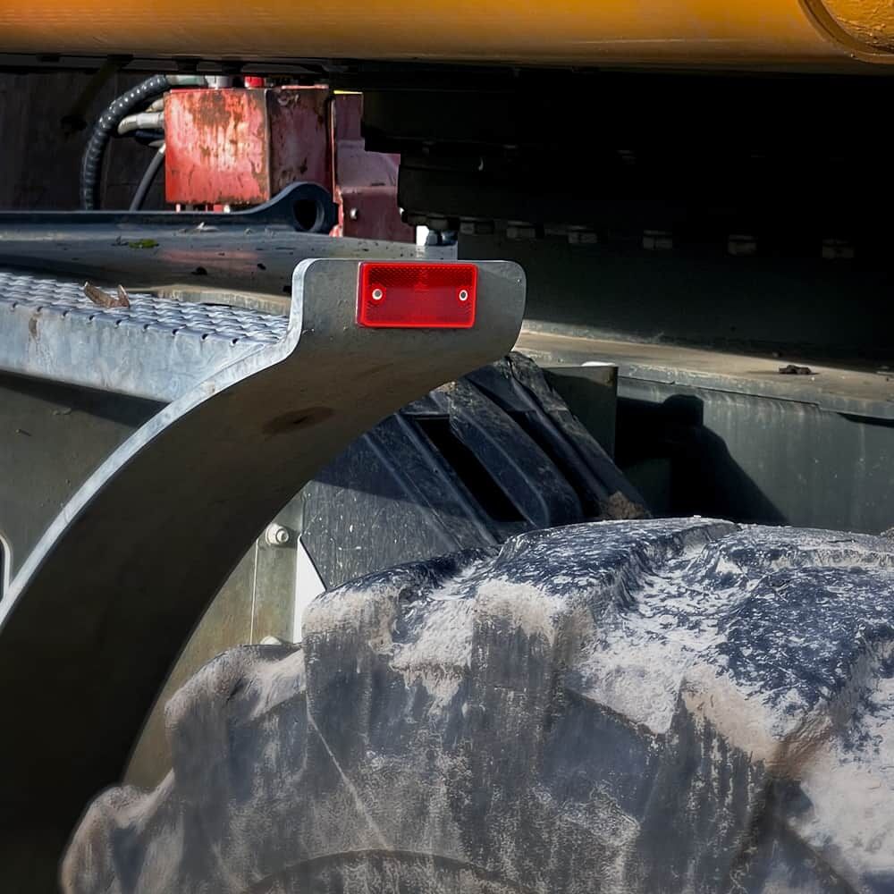 Roter Reflektor 94×44 mm an Baumaschinenkotflügel montiert