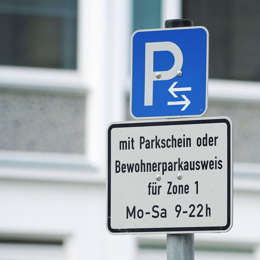 Parkplatzschild „P“ mit Pfeilen links/rechts, Zusatzschild Parkschein/Bewohner Zone 1
