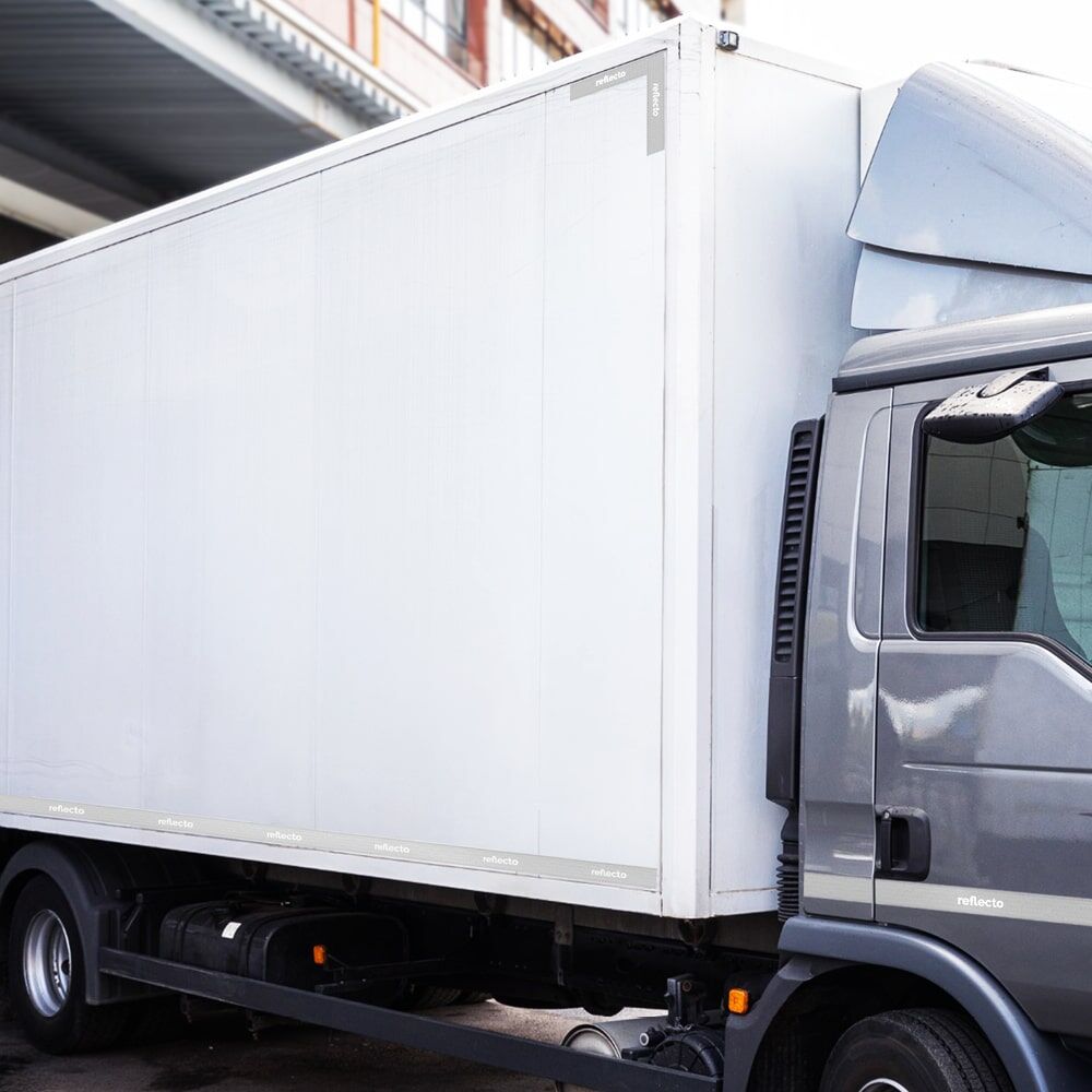 Weißer LKW mit umlaufender 3M Konturmarkierung und mehrfachen reflecto-Logos