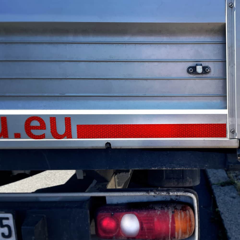 Rote VC 104 Konturmarkierung mit Firmenlogo am Heck eines Lieferfahrzeugs