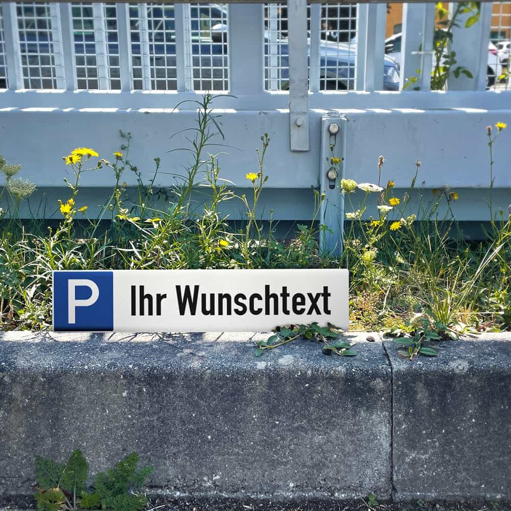 Parkplatzschild mit Wunschtext im Außenbereich montiert