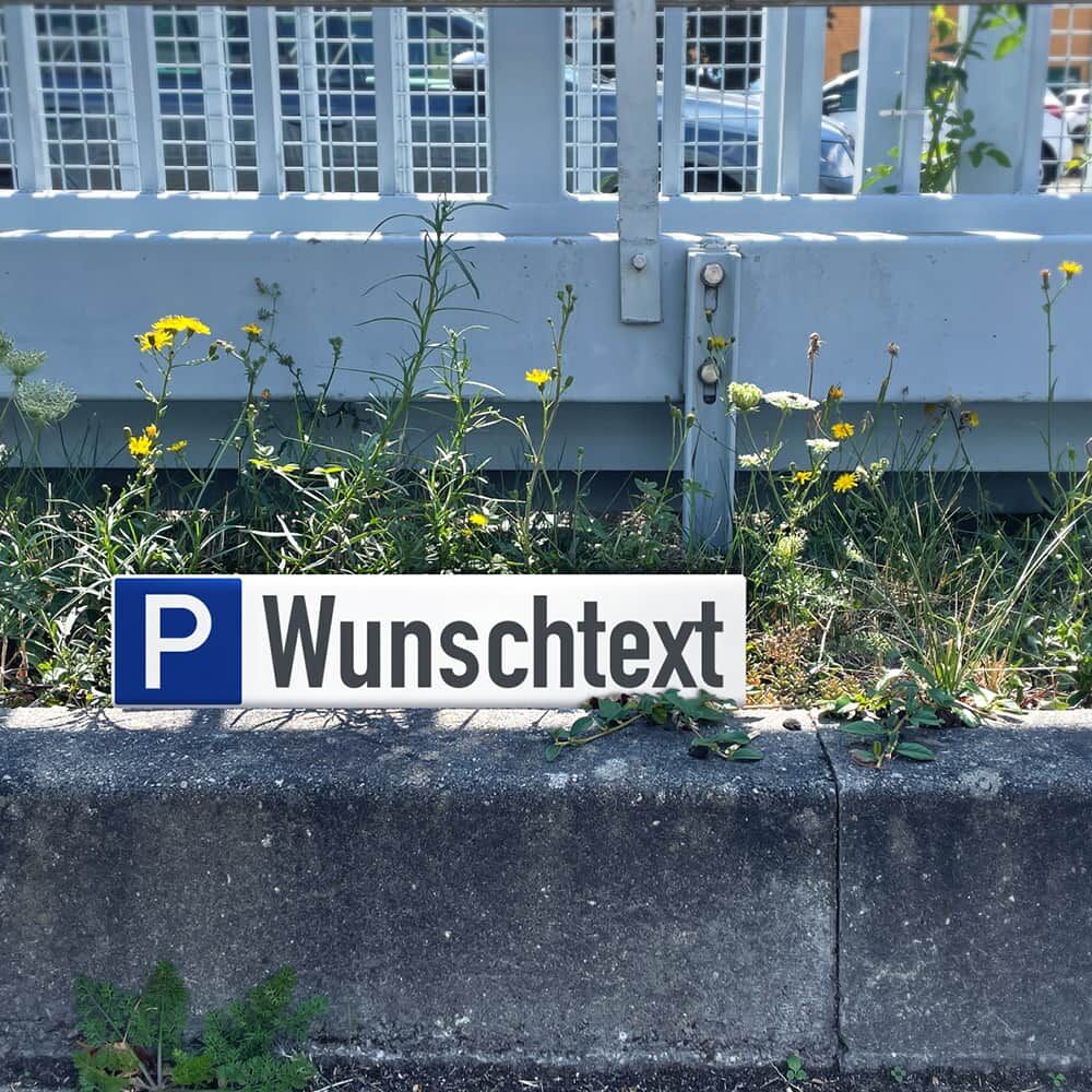 Parkplatzschild mit Wunschtext im Außenbereich montiert