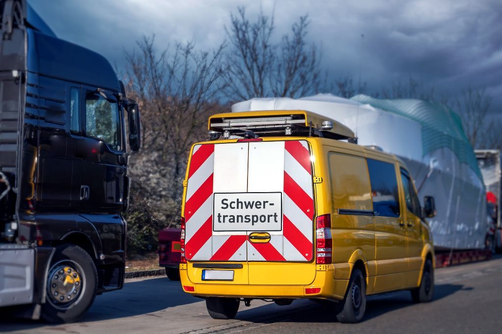 Anwendungsbeispiel eines Begleitfahrzeuges, ausgestattet mit Warnmarkierung und Schild